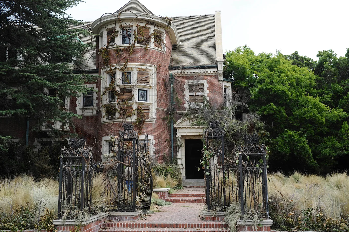 The Murder House exterior appears behind a gate in a Season 1 publicity photograph.
