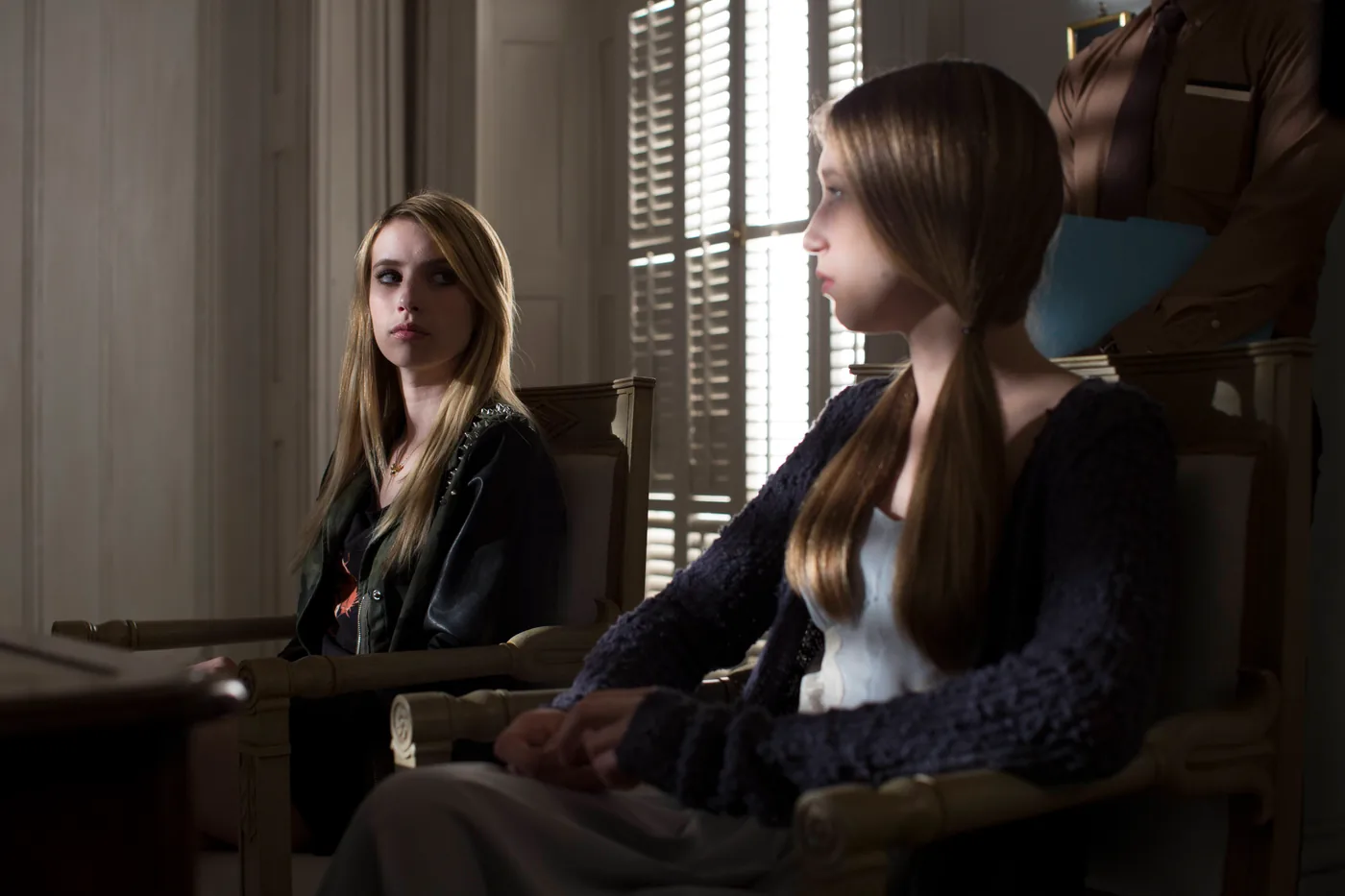 Two young witches sit inside Miss Robichaux's Academy in a Coven publicity photograph.