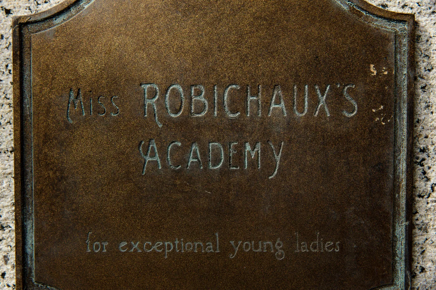 A weathered plaque at the gate identifies Miss Robichaux's Academy for exceptional young ladies in a Coven publicity photo.