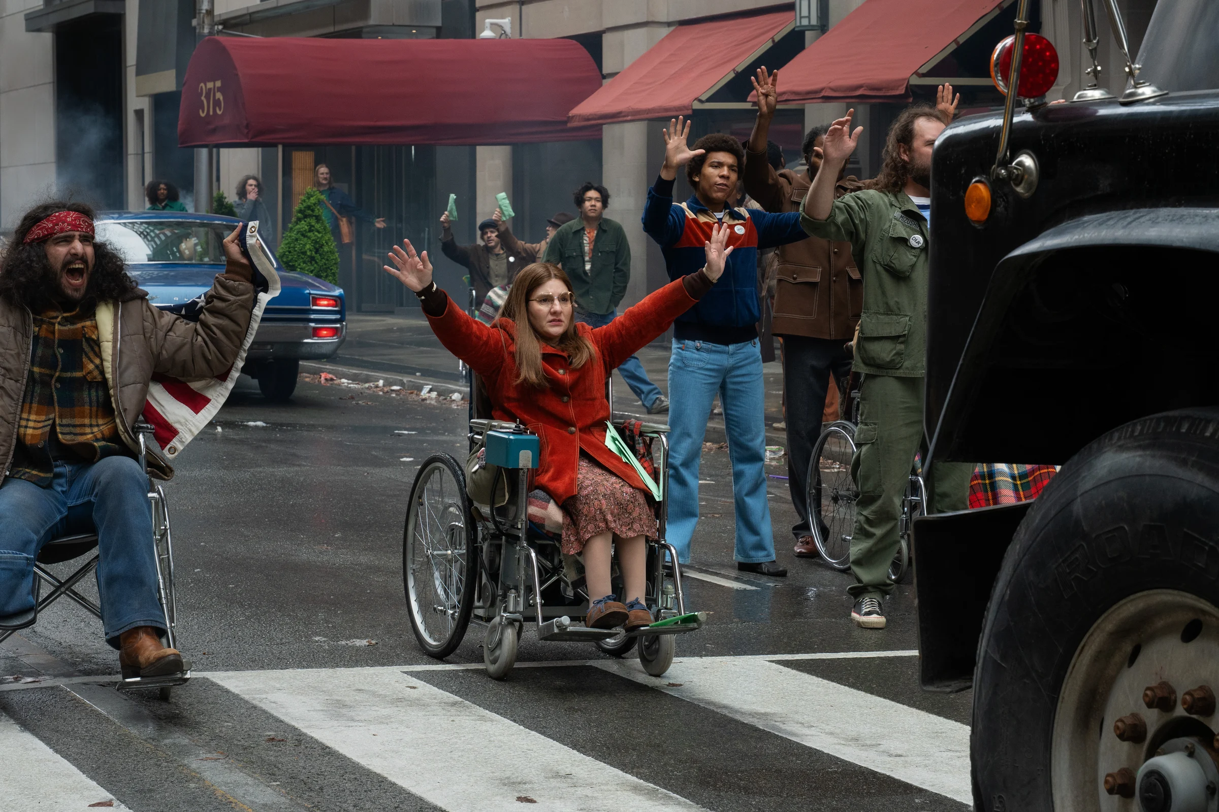 Ruth Madeley as Judy Heumann raises her hands during a street confrontation in an official still from Being Heumann.