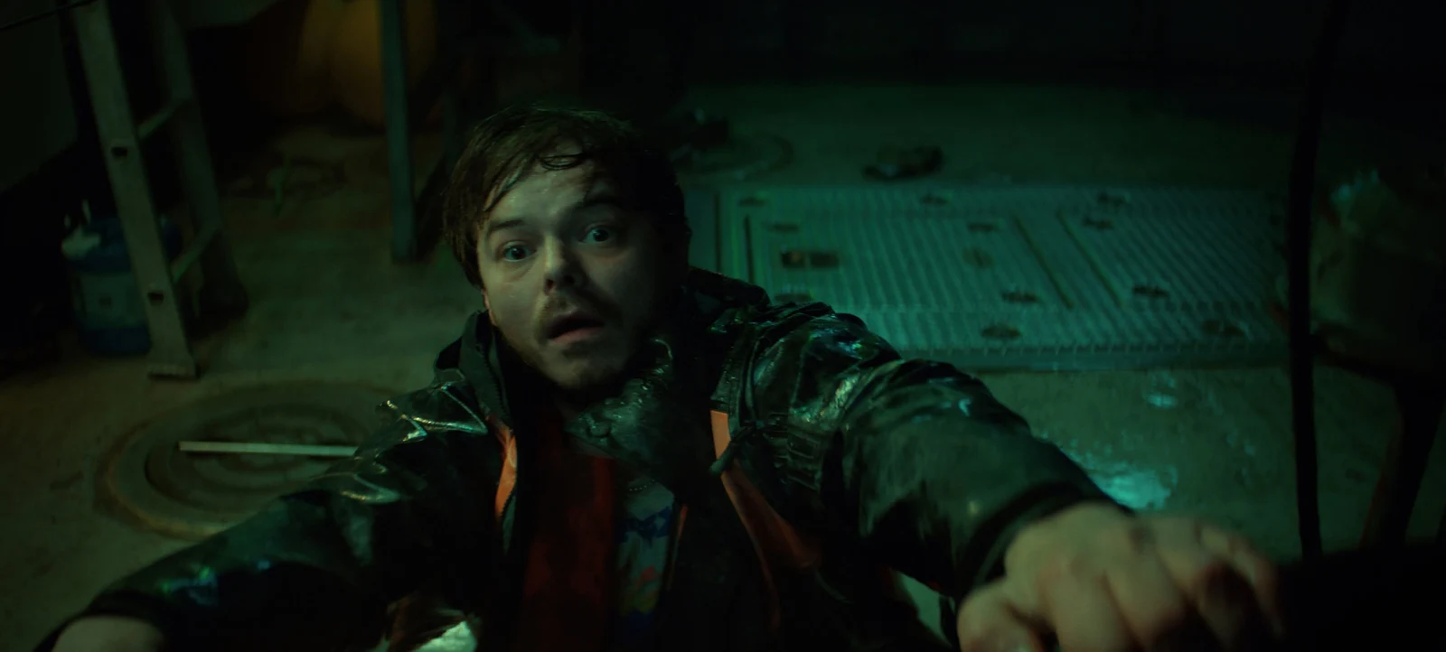 Netflix Charlie Heaton as Wade Penney looking shaken and reaching toward camera in a dark, water-damaged setting in Netflix's Below.