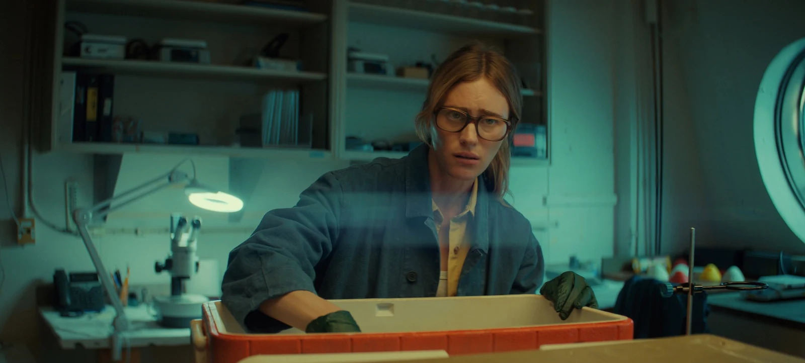 Netflix Mackenzie Davis as Fonda Howander examining samples in a lab in Netflix's Below.