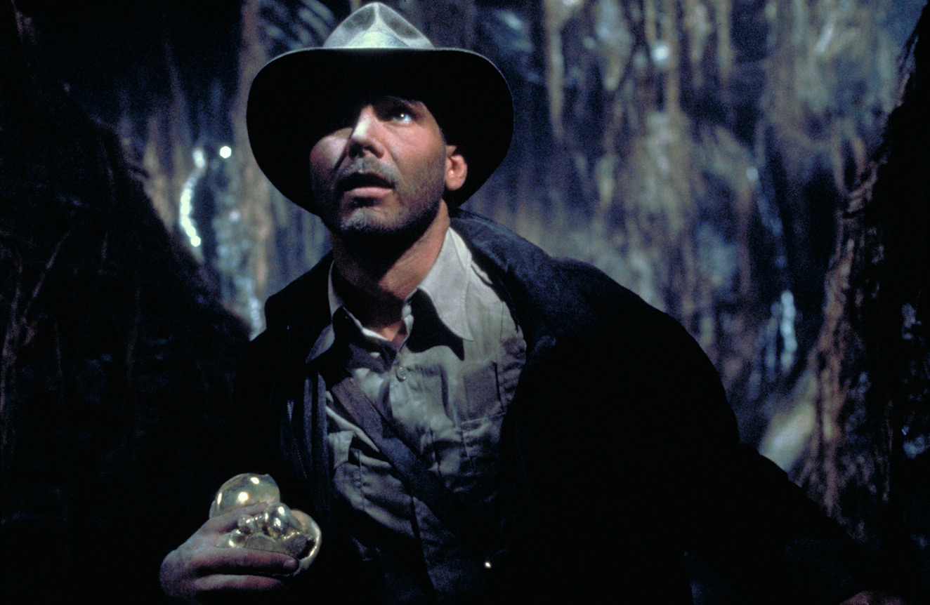 Harrison Ford as Indiana Jones inside a temple in an official Raiders of the Lost Ark still.