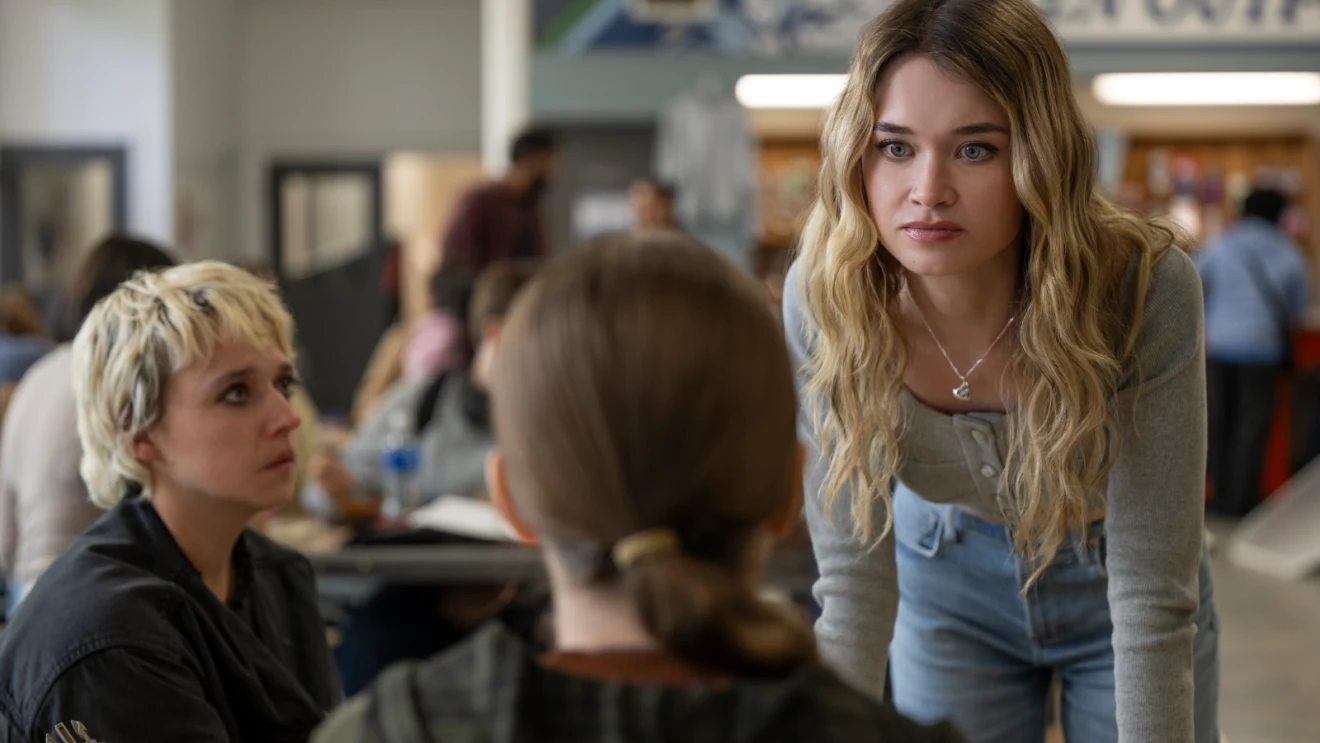 Alison Thornton as Chris Hargensen leaning toward Carrie in a tense school cafeteria encounter.