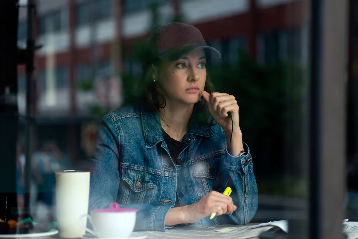 Shailene Woodley as fictional FBI agent Joanne Miller holds a highlighter over documents in a diner in Netflix’s UNABOMBER.