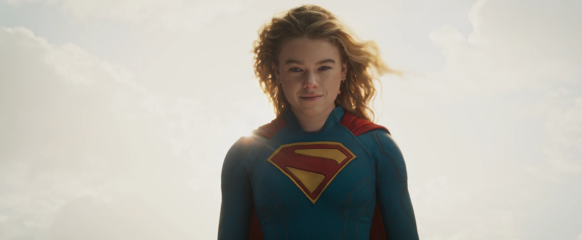 Milly Alcock as Kara Zor-El in costume against a bright sky in official Supergirl imagery released alongside Warner Bros. Discovery's HBO Max streaming-date announcement.