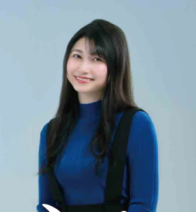 Sora Amamiya seated in a blue top against a light blue background in a Japanese government radio-publicity photograph.