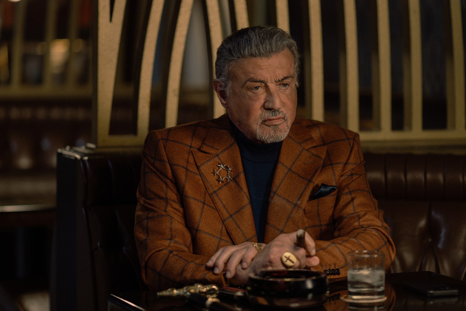 Sylvester Stallone portraying Dwight Manfredi in a restaurant scene from Paramount+'s Tulsa King.